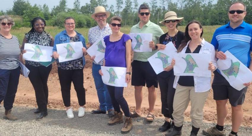 Sandra Moore and the team at the Cleantech Academy build site in Georgetown hold renderings of the future Cleantech Park